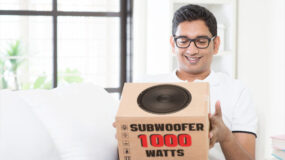 A man holding a subwoofer box
