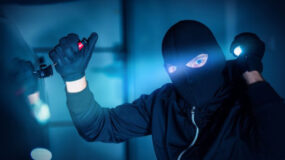 A thief being caught in the act of breaking into a car