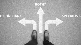 A man's feet standing on a road with three options shown by arrows leading off in various directions